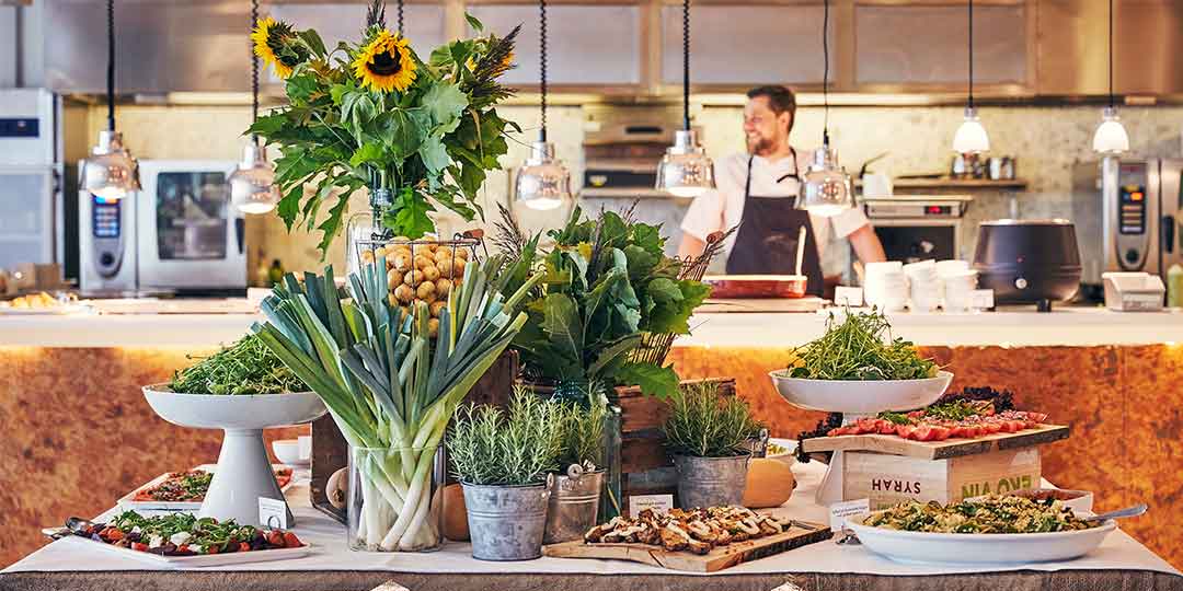 mat-dryck-stockholmsmässan-1080x540px Bild på en av restaurangerna på Stockholmsmässan med en uppdukad buffé fylld med plockmat så som sallad och grönsaker