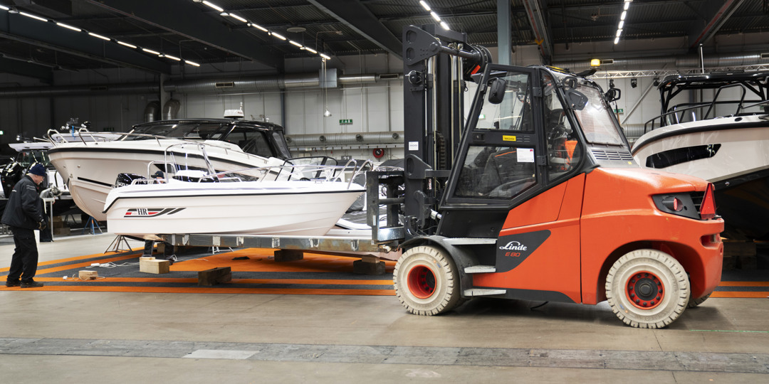 Produkter och tjänster 3 Orange truck som flyttar en motorbåt under Allt för sjön