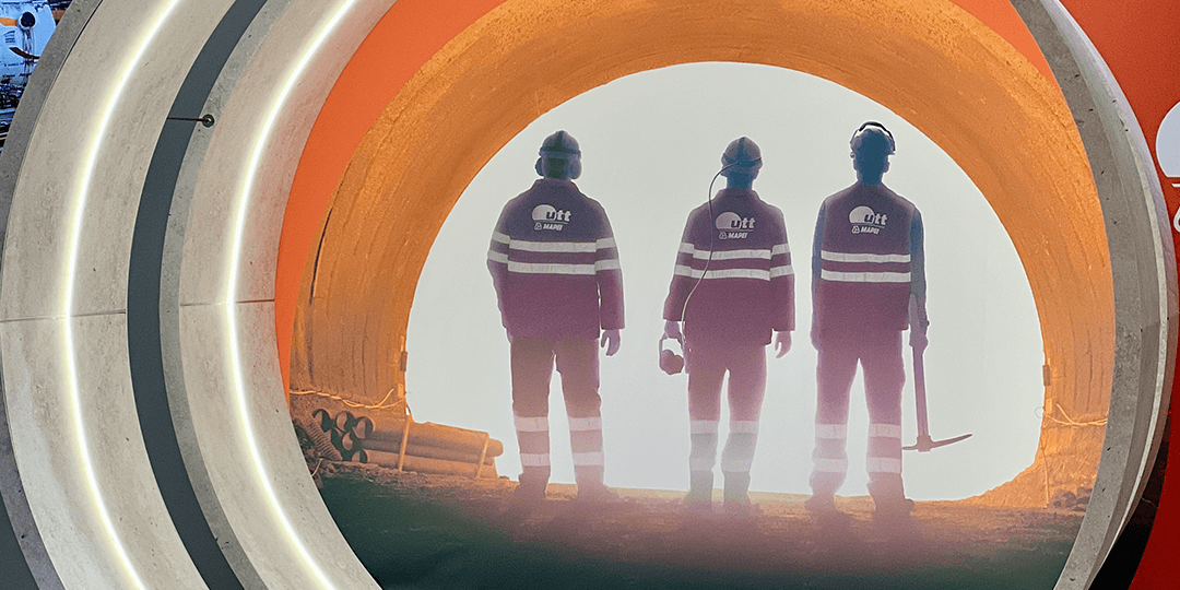 Startsida 16 Utställningsportal med bild av tre tunnelarbetare upplysta bakifrån, stående i en tunnel under World Tunnel Congress på Stockholmsmässan.